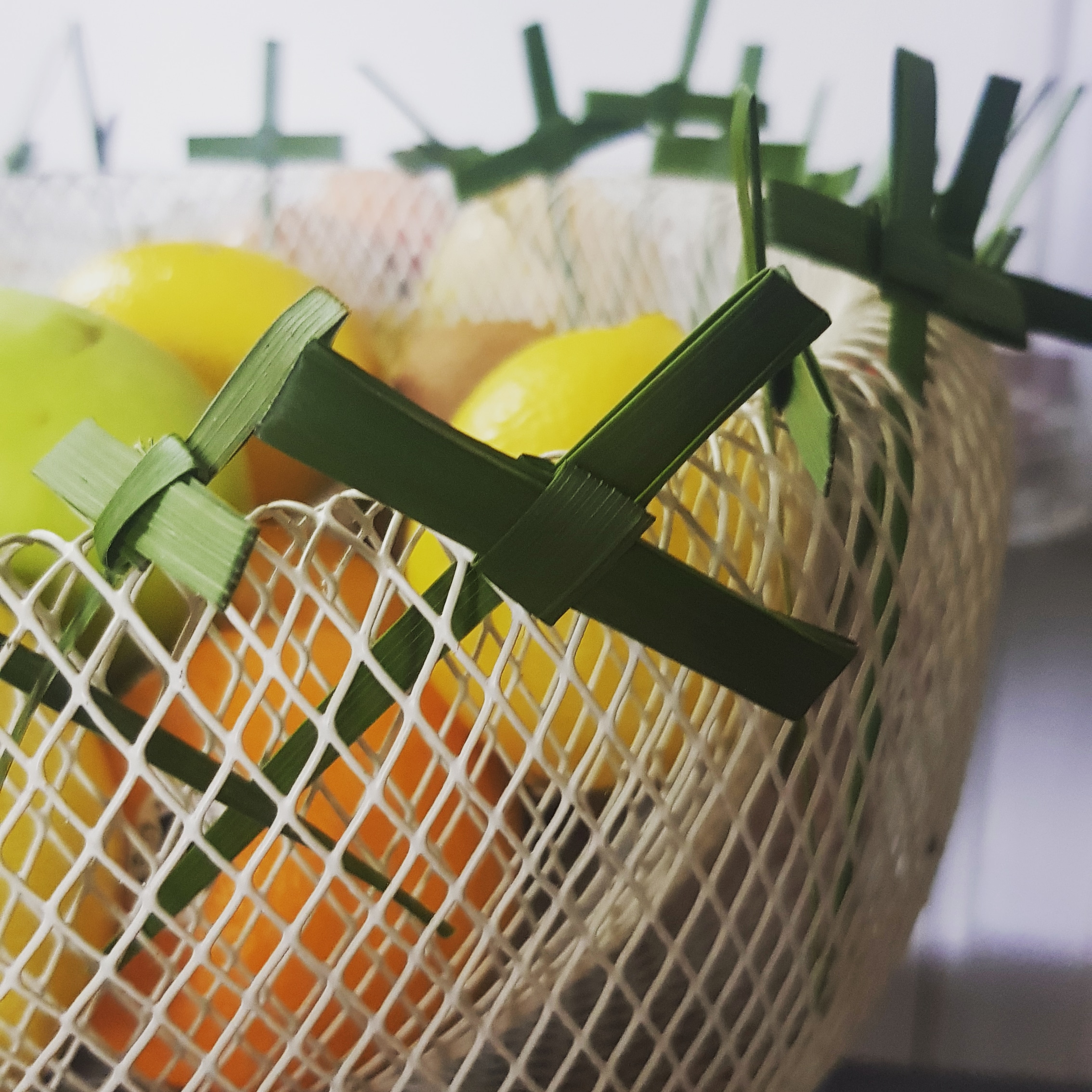 ash wednesday crosses are tucked into the edge of a mesh fruit bowl lent 2020